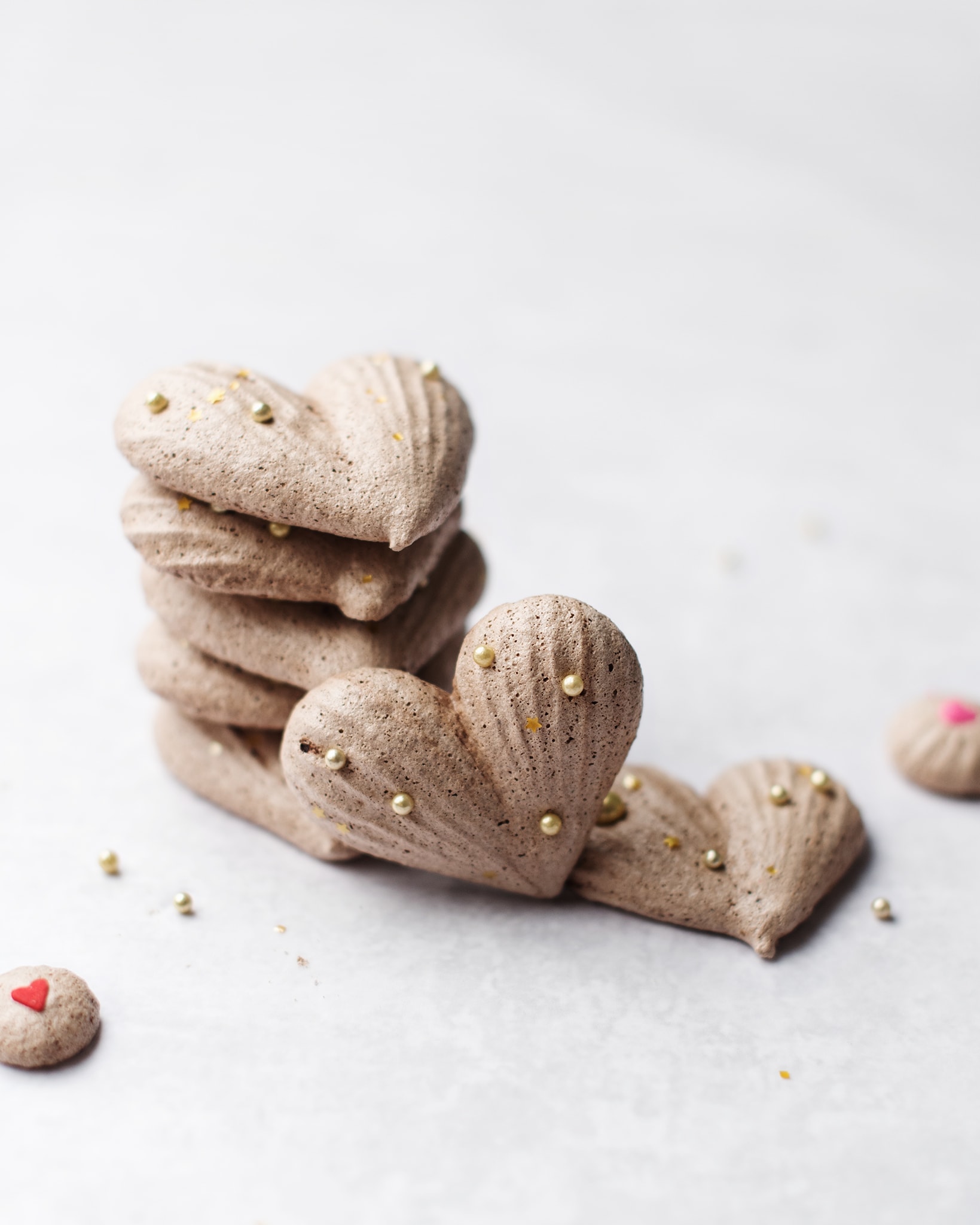 A stack of heart-shaped chocolate meringues with gold sprinkles