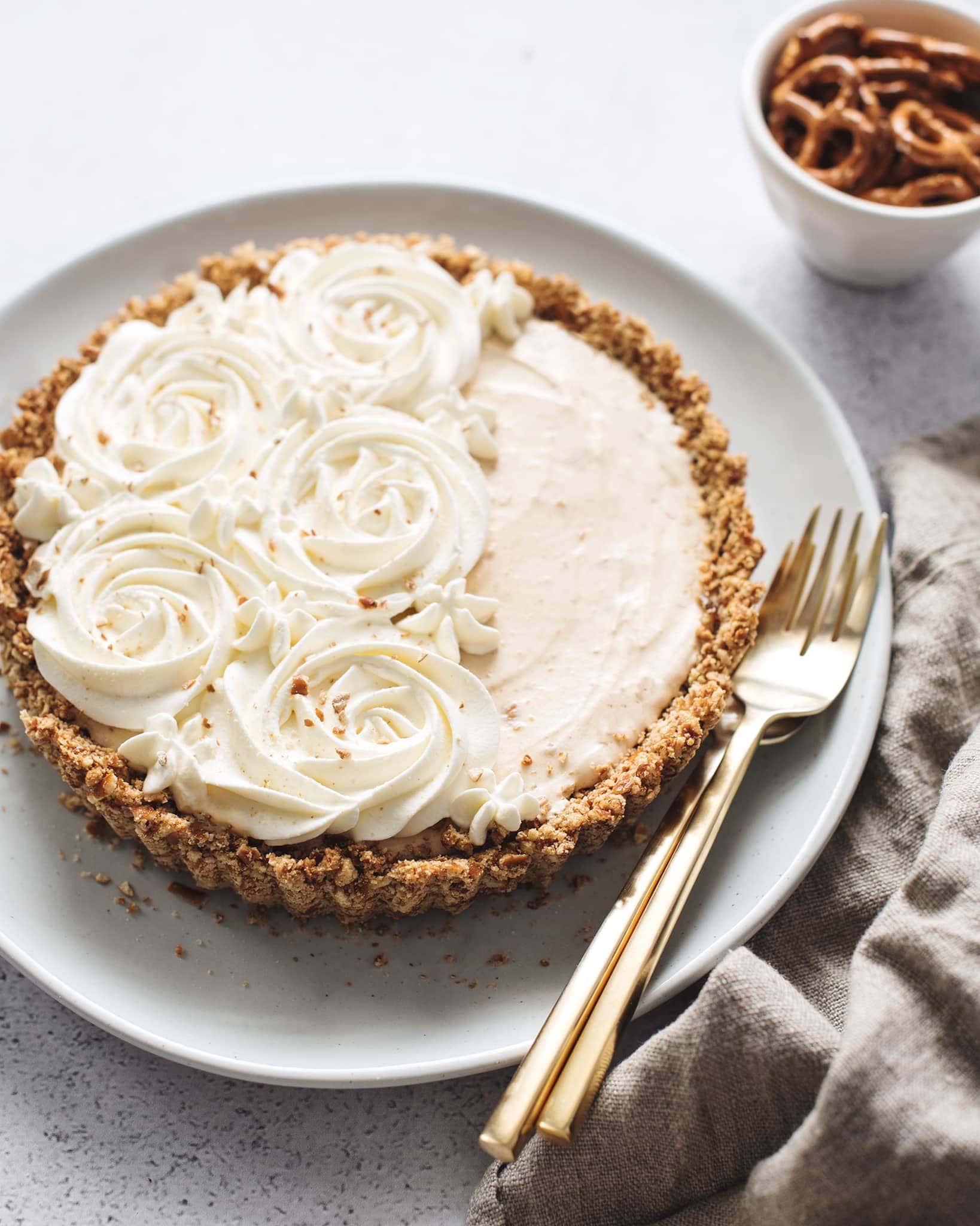 Peanut butter ice cream pie with whipped cream rosettes and brown linen