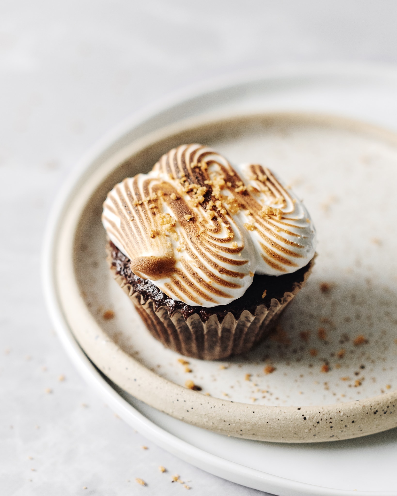 Close up of one s'mores cupcake with toasted marshmallow meringue