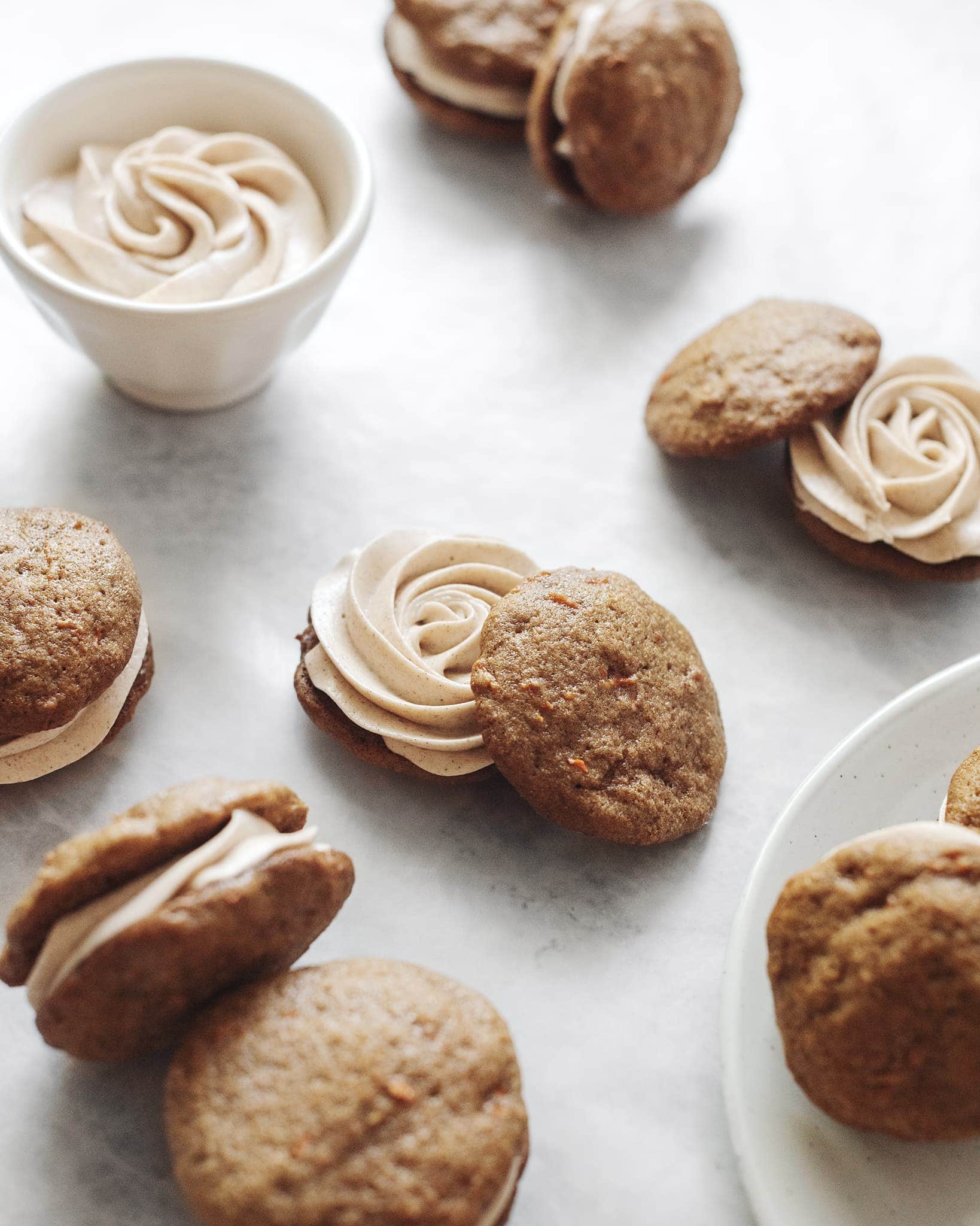 Cream cheese piped in a swirl on carrot cake cookies