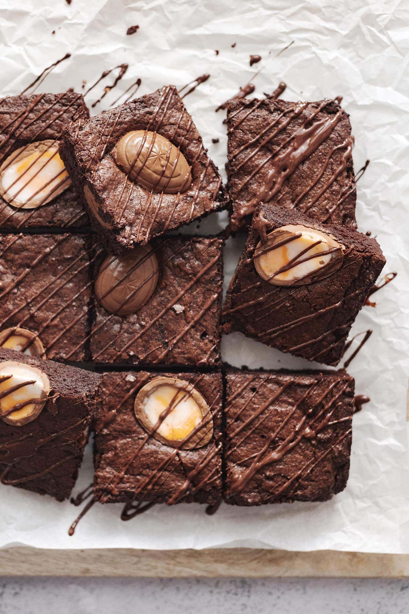 Squares of creme egg brownies with chocolate drizzle