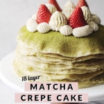 Close up of crepe cake layers topped with strawberries and whipped cream