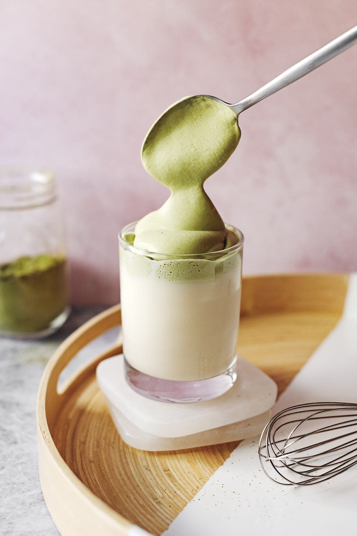 Spooning whipped matcha cream into glass cup
