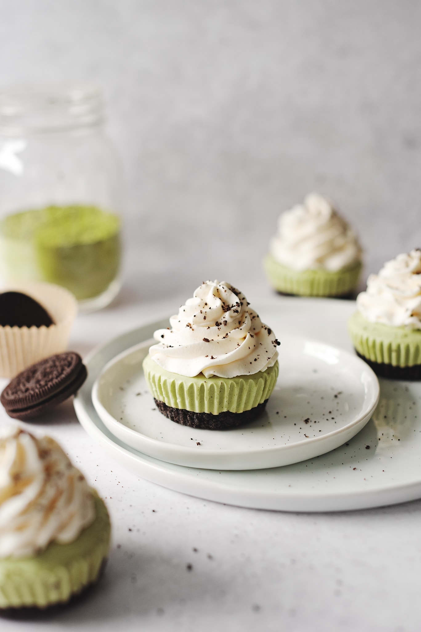 No-bake matcha cheesecake topped with whipped cream on plate with oreos