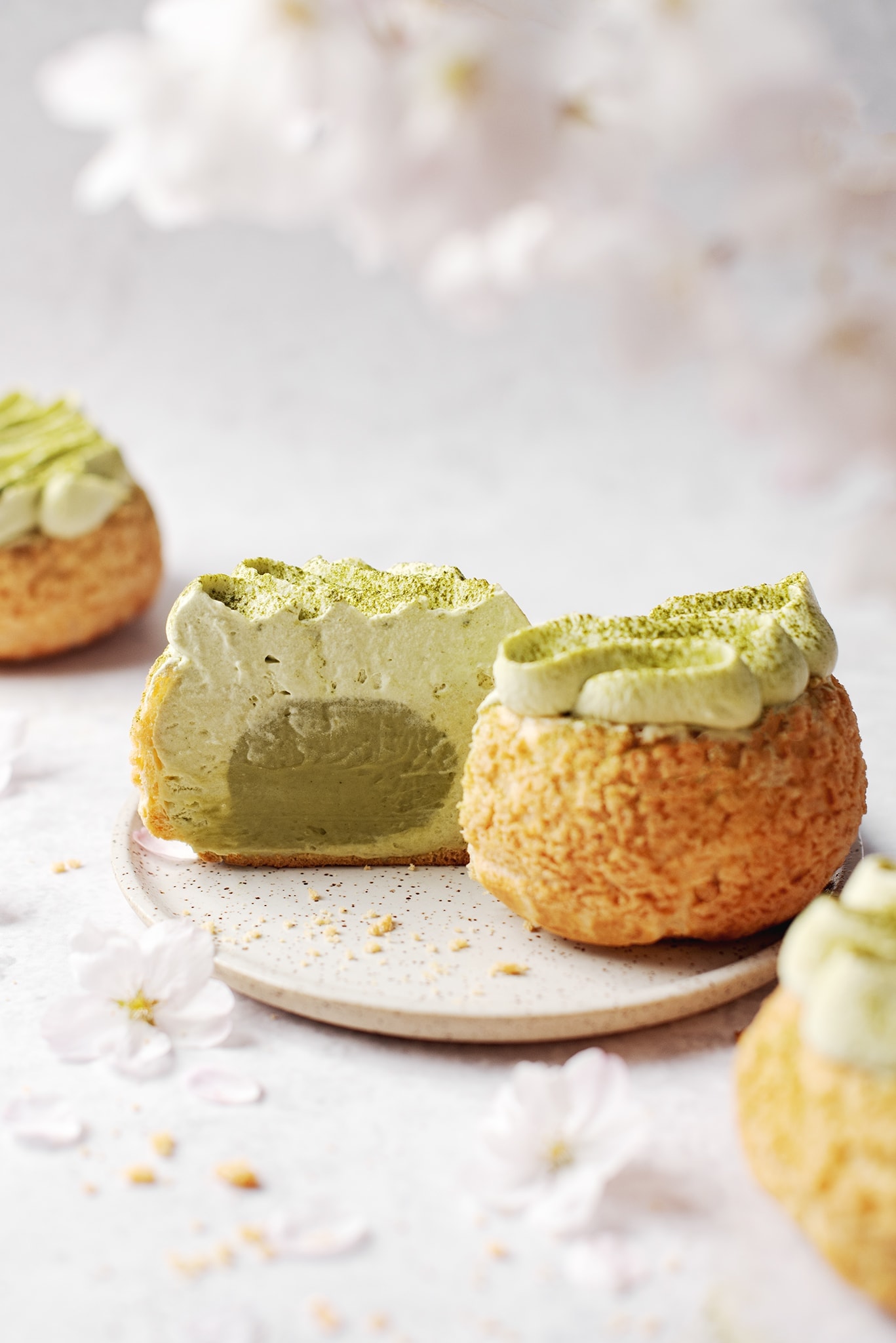 Cream puffs cut in half to show matcha pastry cream inside