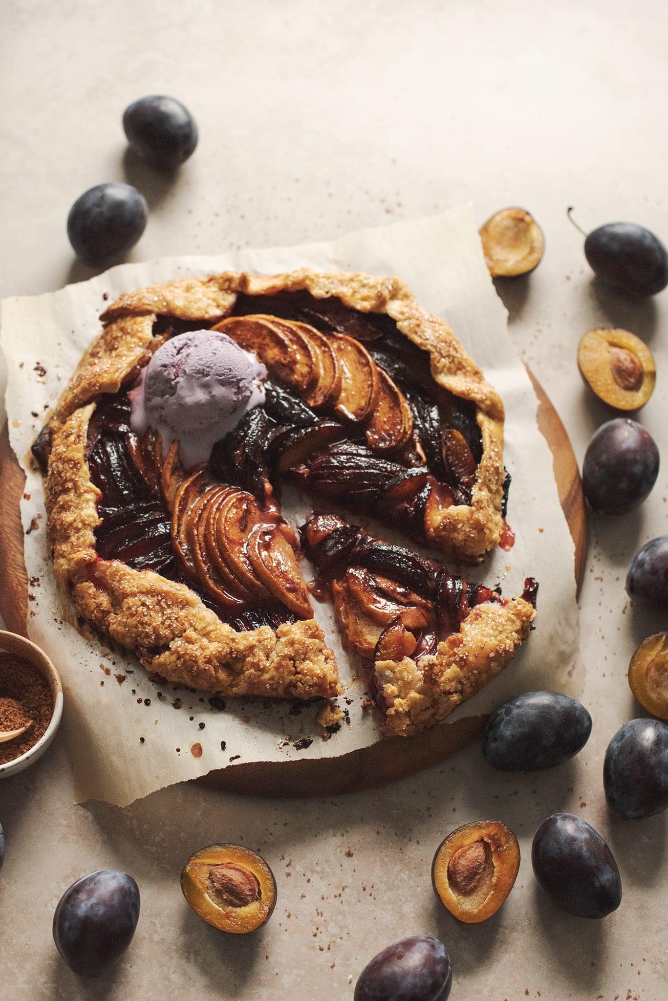 Glossy peach plum galette with a scoop of melting ice cream