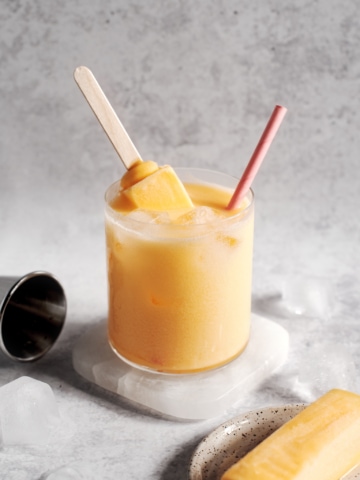 Mango melona soju cocktail with melona popsicle sticking out