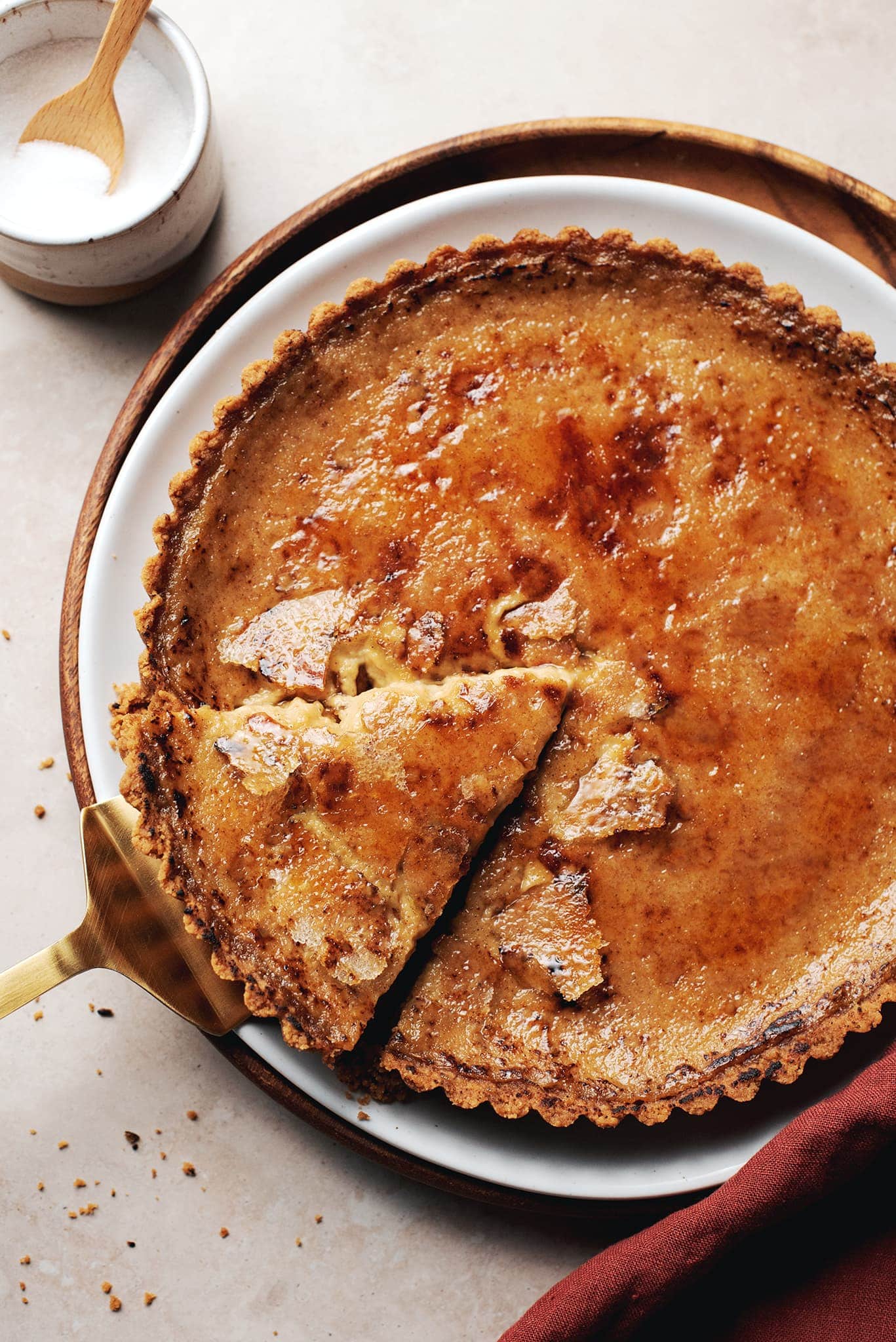 pumpkin crème brûlée tart with a slice cut out of it