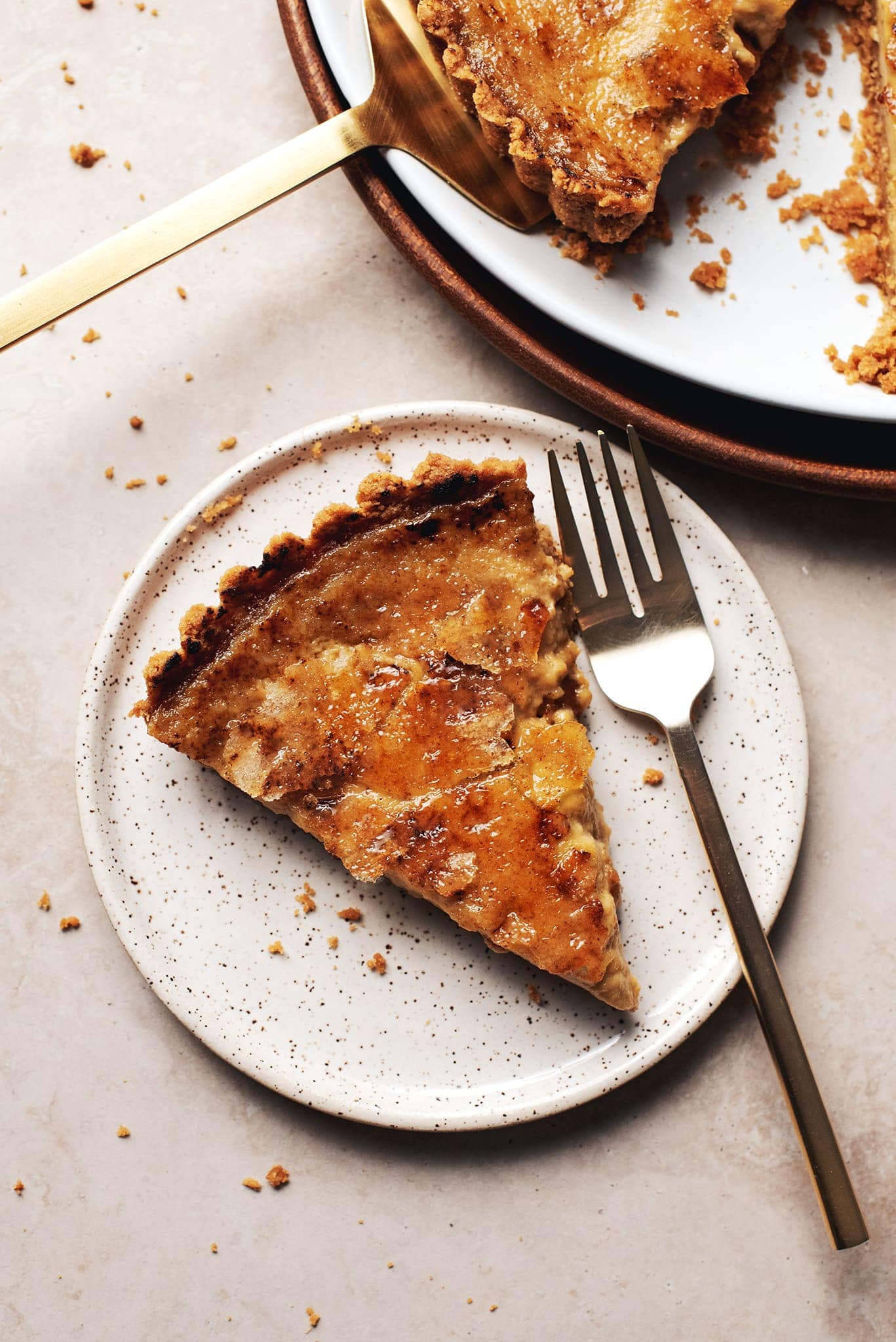 slice of pumpkin crème brûlée tart on a plate with fork