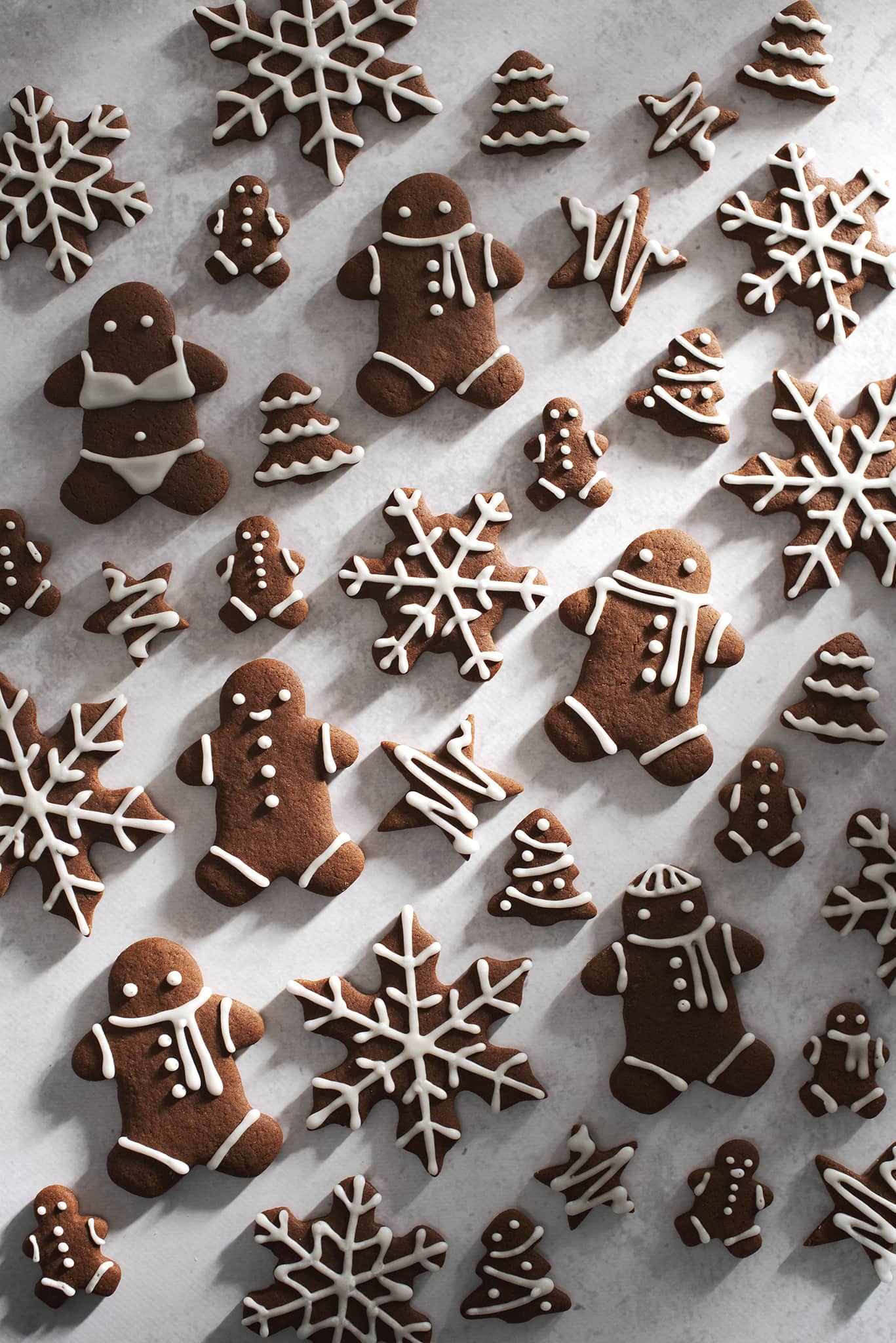 cut out gingerbread cookies scattered on grey surface