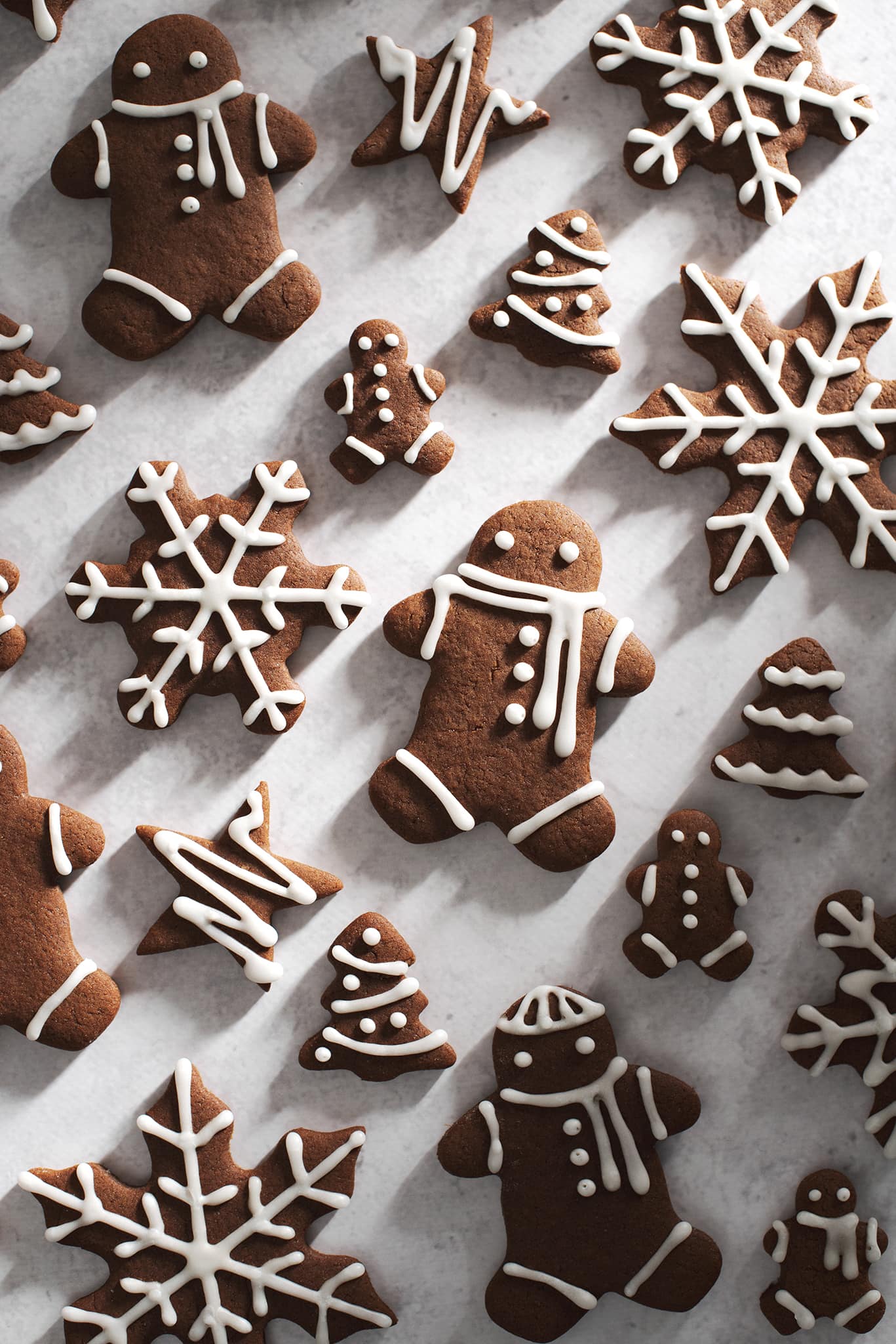 decorated gingerbread men and snowflakes on grey surface