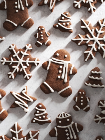 decorated gingerbread men and snowflakes on grey surface