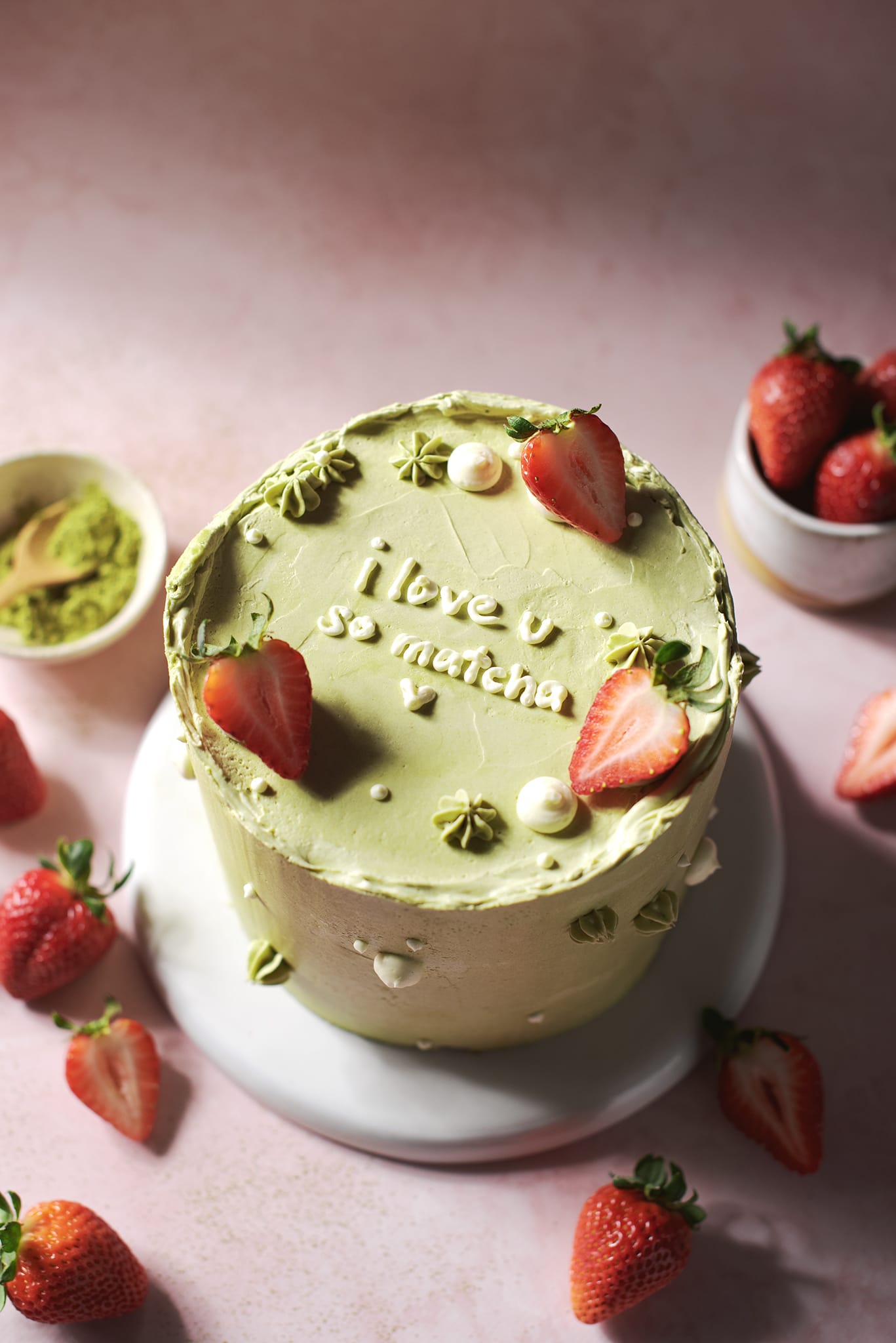 matcha strawberry cake that says “i love u so matcha” on top
