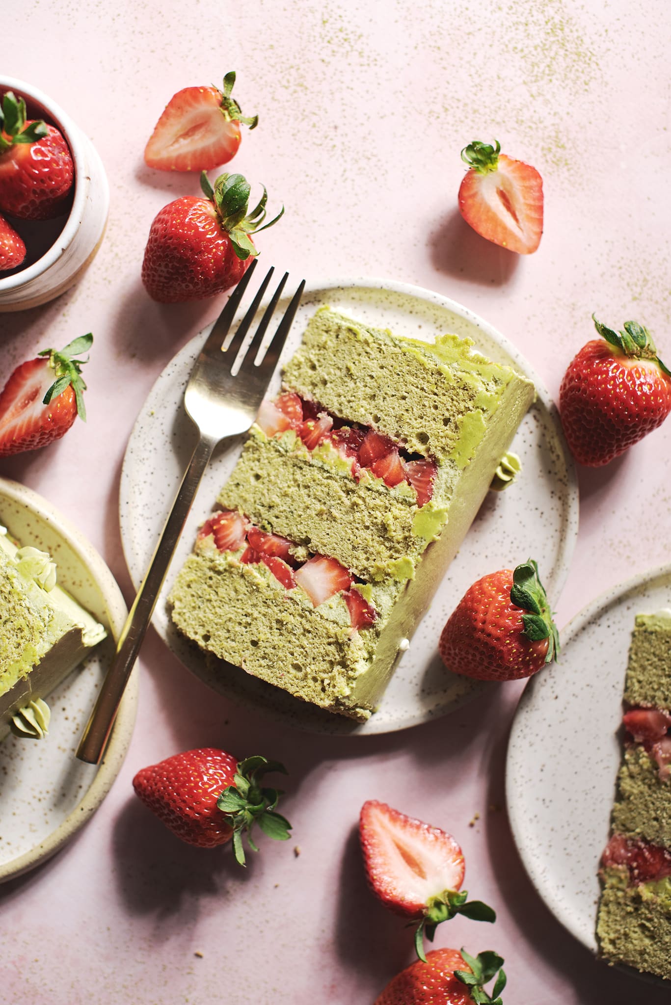 slice of matcha sponge cake with layers of strawberries
