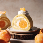 slice of orange swiss roll with mandarin orange in the middle