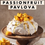 mango passionfruit pavlova on a wooden cake stand
