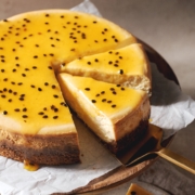 A slice of passionfruit cheesecake on a gold cake server.
