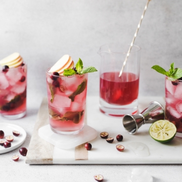 Cranberry apple mojitos on a marble and wood serving tray