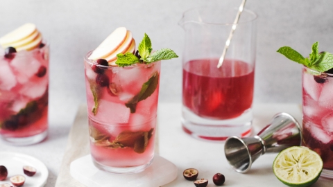 Cranberry apple mojitos on a marble and wood serving tray