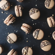 Macarons scattered on black background