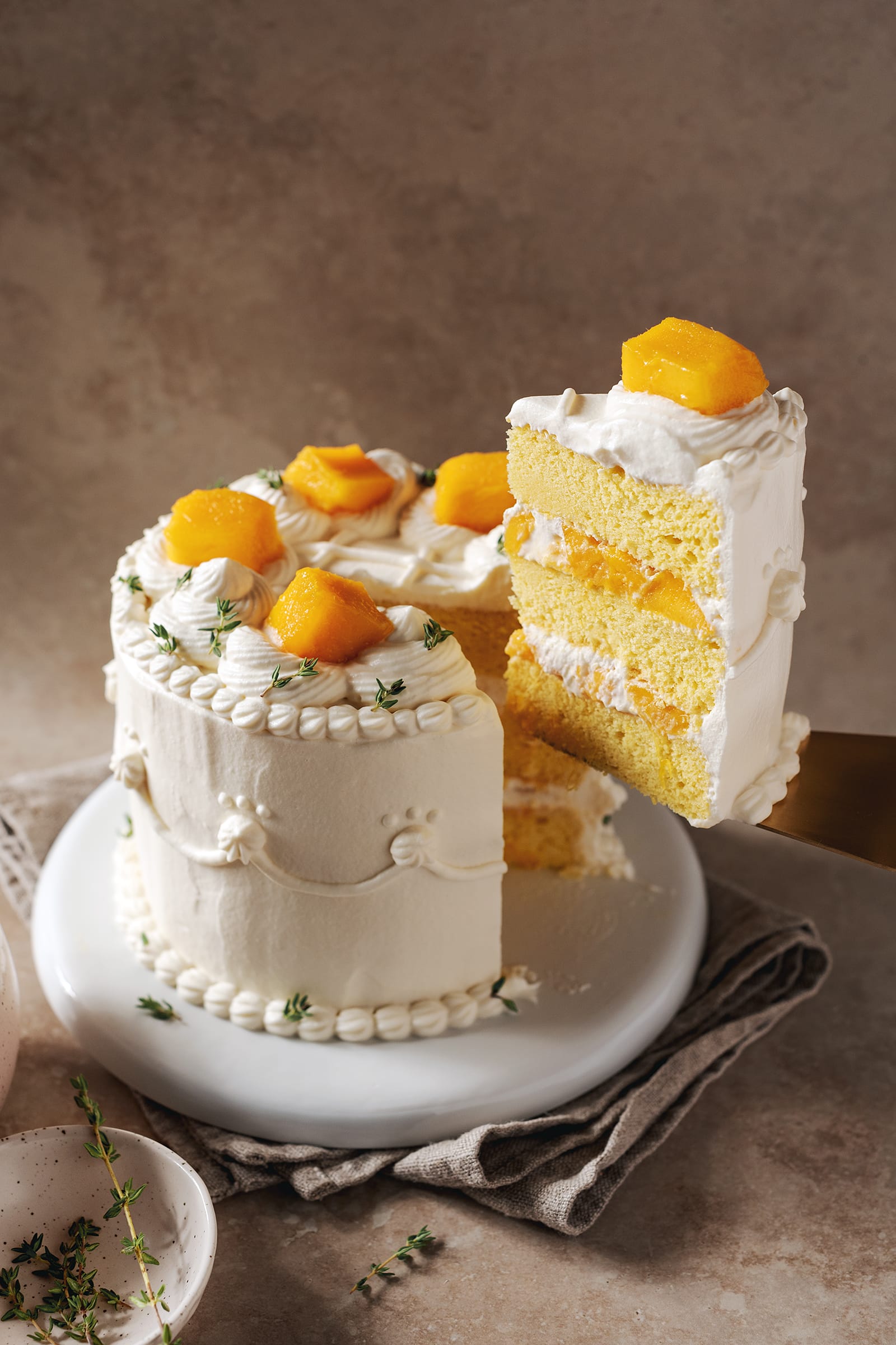 A slice of mango chiffon cake lifted from the cake with a cake server.