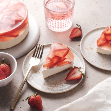 A slice of strawberry jelly cheesecake cut from the cake