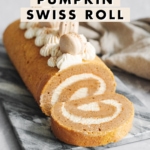 A slice of pumpkin swiss roll cut and laying in front of the roll cake.