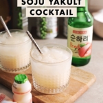 Soju yakult cocktail in a glass with soju bottle in the background and yakult in the foreground.