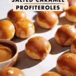 Profiterole with a caramel drip down the side surrounded by more cream puffs.