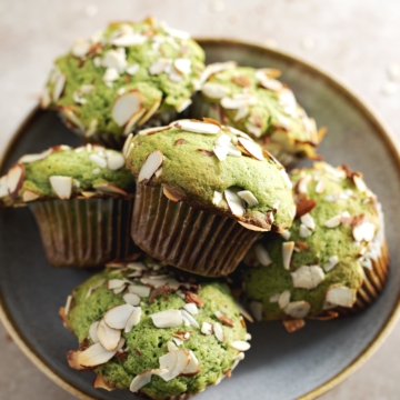 A stack of matcha muffins sitting in a bowl.