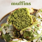 A matcha muffin cut in half to show texture sitting on top of pile of muffins.