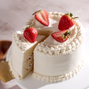 Strawberry chiffon cake with a slice cut out of it.