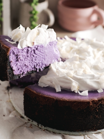 A slice of ube cheesecake lifted from the rest of the cheesecake.