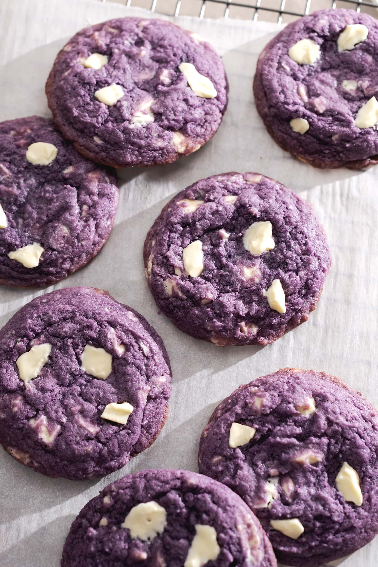 Several ube cookies scattered on a wire rack.