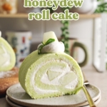 A slice of honeydew roll cake on a stack of plates.