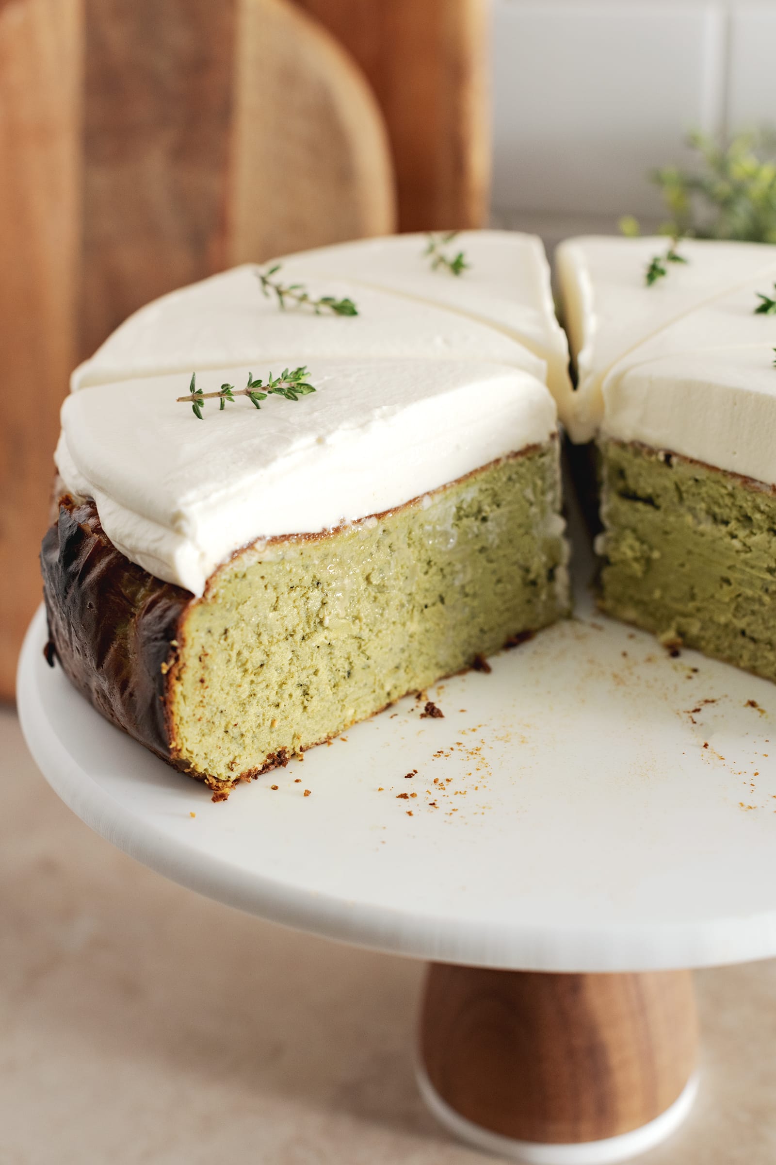 Cross section of a cheesecake with matcha and whipped cream layers.
