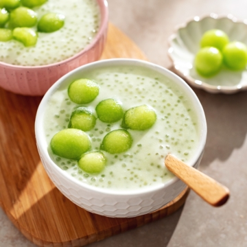 A bowl of honeydew sago pudding with honeydew melon balls on top.