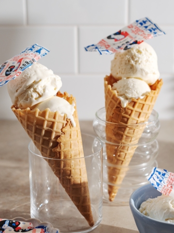 Two white rabbit ice cream cones standing up in glasses.