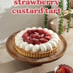 Strawberry tart on a wooden cake stand with strawberries scattered on tabletop.