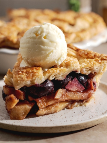 Side view of a slice of pie with scoop of ice cream on top.