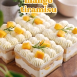 Four containers of mango tiramisu on a wooden platter with greenery around it.
