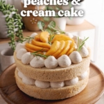 Two-layer peaches and cream cake on a wooden cake stand surrounded by peaches and plants.