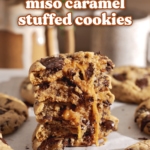 A stack of miso caramel cookies cut in half to show the goey caramel inside.
