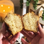 Hands holding a muffin cut in half to show the texture inside.