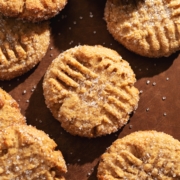 Overhead view of peanut butter miso cookies scattered on a wooden board.