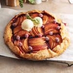 A cranberry apple galette sitting on a wire rack on a kitchen counter.