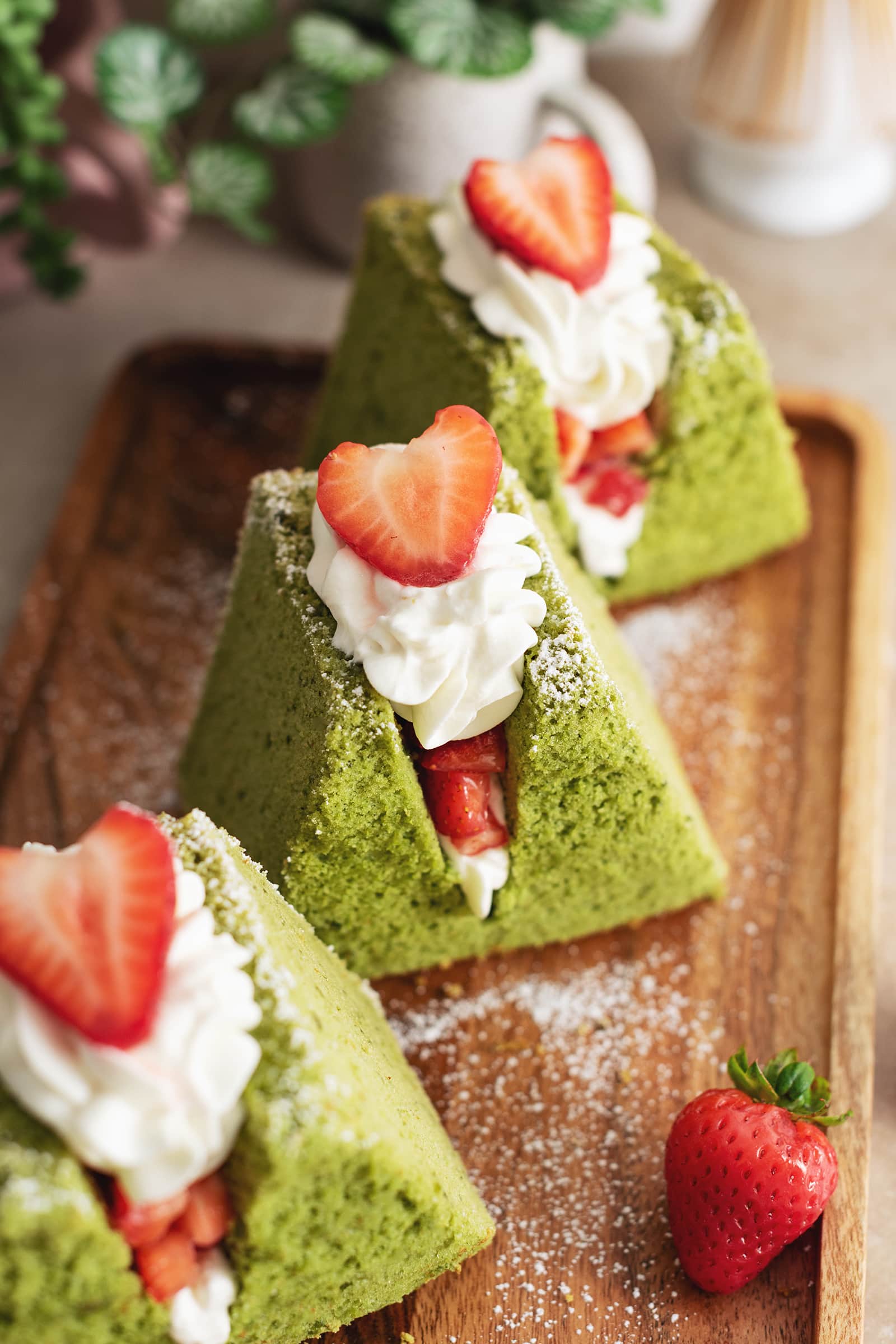 Close-up of a matcha chiffon cake sandwich filled with whipped cream and strawberries.