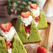 Close-up of a matcha chiffon cake sandwich filled with whipped cream and strawberries.