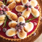 Toasted meringue piped in the shape of flowers on top of a cranberry curd tart.