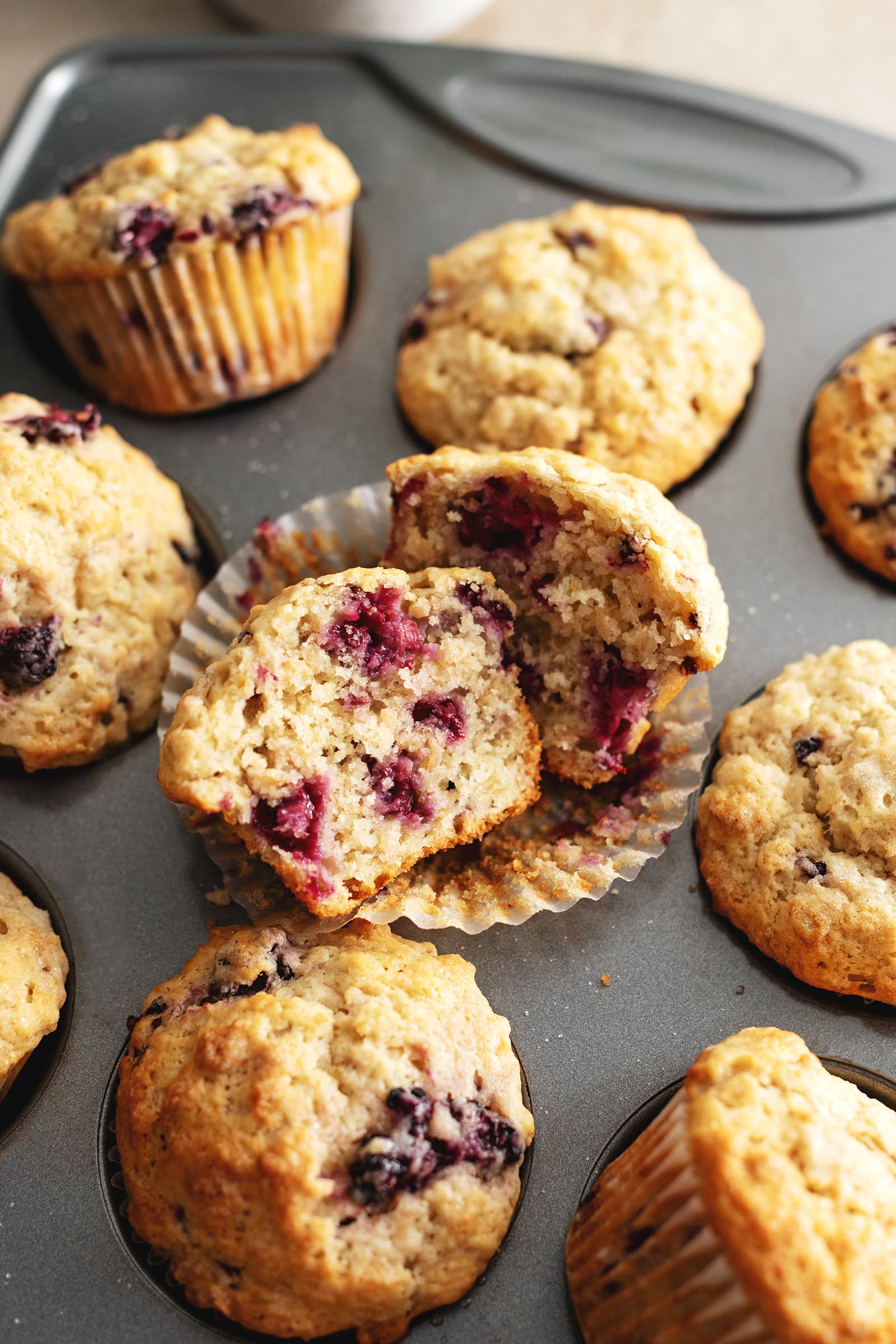 A banana blackberry oatmeal muffin cut in half to show the texture inside.
